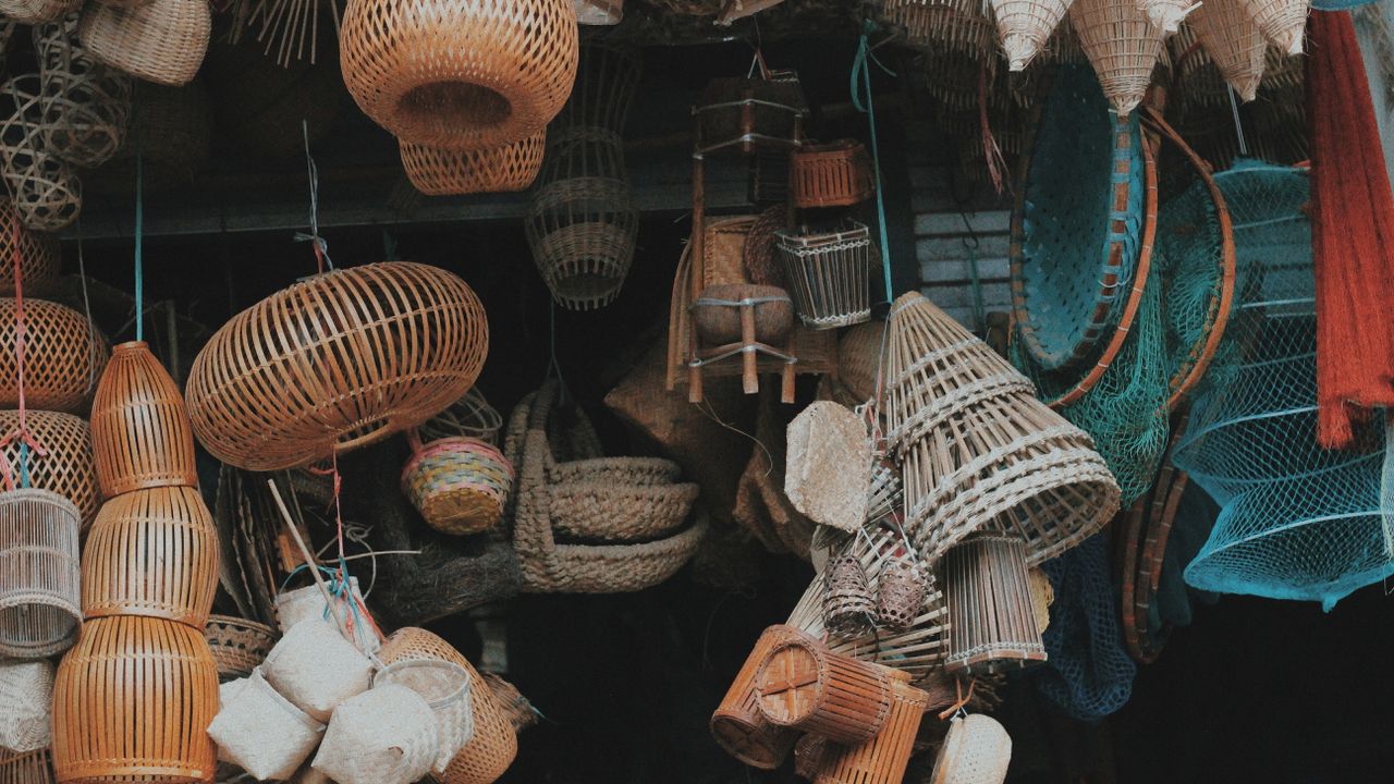 Woven baskets and rattan goods hanging at a market stall in Southeast Asia